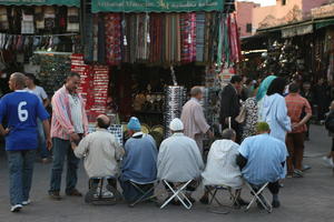 autumn, dusk, eye level view, group, man, market, Marrakech, Marrakesh, middleastern, Morocco, people, sitting, stall