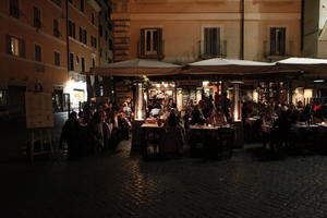 artificial lighting, eating, eye level view, furniture, group, Italia , Lazio, night, outdoor lighting, people, restaurant, Rome, sitting, street, summer, umbrella