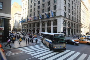 afrocarribean, building, bus, car, couple, crossing, day, elevated, flag, Manhattan, New York, people, standing, street, summer, sunny, taxi, The United States, walking