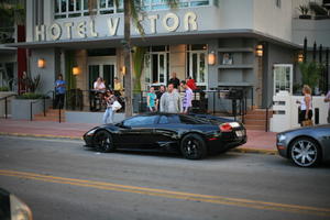 building, car, dusk, eye level view, facade, Florida, hotel, Miami, people, railing, sitting, standing, street, The United States, winter