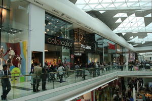 day, England, eye level view, group, indoor lighting, interior, London, mall, natural light, people, retail, shop, shopping, shopping centre, sign, The United Kingdom, walking