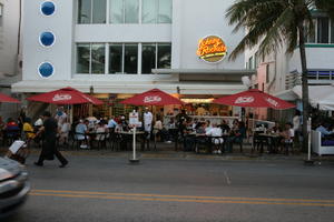 artificial lighting, chair, evening, eye level view, Florida, furniture, group, Miami, object, parasol, people, restaurant, sign, sitting, street, table, The United States, waiter