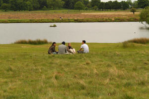 casual, day, diffuse, diffused light, England, eye level view, grass, group, lake, London, natural light, park, people, sitting, spring, The United Kingdom