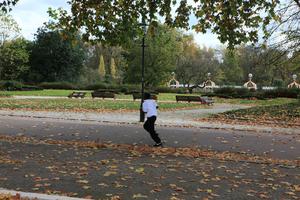 afternoon, autumn, Battersea park, bench, boy, child, day, England, eye level view, leaf, London, park, path, running, The United Kingdom, tree