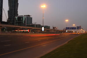 artificial lighting, cityscape, Dubai, Dubayy, dusk, eye level view, flyover, lamppost, outdoor lighting, road, sign, The United Arab Emirates