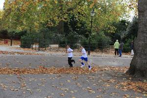 afternoon, autumn, Battersea park, child, day, England, eye level view, group, leaf, London, park, path, running, The United Kingdom, tree