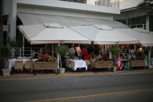 building, cafe, canopy, chair, dusk, eye level view, Florida, Miami, object, people, potted plant, sitting, street, summer, table, The United States, walking, winter