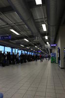 airport, architecture, artificial lighting, ceiling, crowd, England, eye level view, floor, hallway, light, London, people, pipe, queuing, sign, terminal, The United Kingdom, vending machine