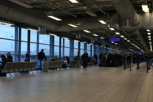 airport, artificial lighting, bin, ceiling, crowd, England, eye level view, floor, hallway, light, London, people, pipe, queuing, sign, standing, terminal, The United Kingdom