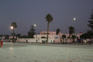 arabic, artificial lighting, autumn, Essaouira, eye level view, group, Morocco, night, palm, people, square, vegetation, walking, woman