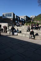 day, England, eye level view, group, Oxford, pavement, people, sitting, steps, sunny, The United Kingdom, urban, winter