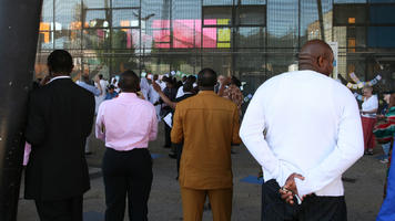 African, afrocarribean, back, crowd, day, England, eye level view, London, people, shady, spring, standing, The United Kingdom