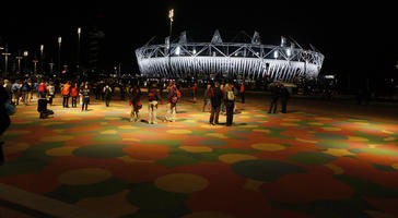 artificial lighting, casual, England, eye level view, group, London, night, outdoor lighting, people, square, stadium, summer, The United Kingdom, walking