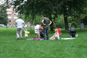 baby, Belgium, Brussels, day, eye level view, family, grass, man, natural light, park, people, sitting, summer, tree, vegetation, woman