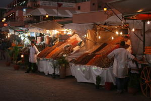 arabic, artificial lighting, canopy, evening, eye level view, food, man, market, Marrakech, Marrakesh, Morocco, object, stall, vendor