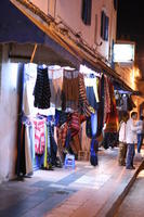 arabic, artificial lighting, autumn, clothing, Essaouira, eye level view, man, market, Morocco, stall