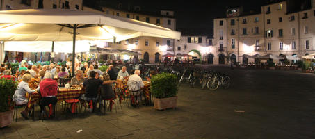 artificial lighting, cafe, chair, eating, eye level view, furniture, group, Italia , Lucca, night, outdoor lighting, outdoors, people, potted plant, sitting, square, summer, Toscana, umbrella