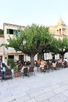 cafe, chair, Croatia, day, dusk, eye level view, furniture, group, Makarska, object, people, potted plant, sitting, Splitsko-Dalmatinska, square, table, tree, vegetation