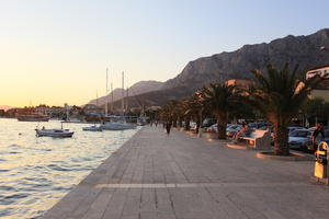 bench, boat, Croatia, dusk, evening, eye level view, Makarska, man, palm, people, promenade, sitting, Splitsko-Dalmatinska, tree, vegetation, walking, woman, yacht