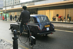 artificial lighting, car, cycling, day, England, eye level view, London, man, natural light, retail, shop, snow, street, sunset, taxi, The United Kingdom, winter, winter