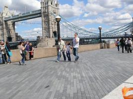 day, England, eye level view, family, group, London, pavement, people, sunny, The United Kingdom