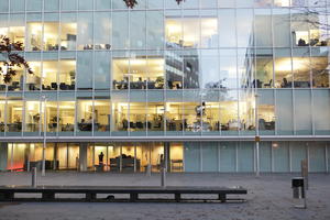 artificial lighting, autumn, bench, building, diffuse, diffused light, England, evening, eye level view, facade, glass, London, office building, outdoor lighting, The United Kingdom