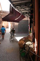 autumn, cycling, day, eye level view, food, man, market, Marrakech, Marrakesh, Morocco, stall, sunny