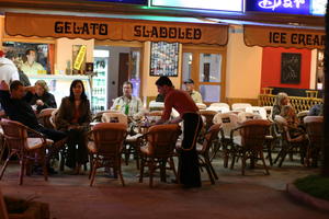 artificial lighting, cafe, chair, Croatia, eye level view, furniture, group, Istarska, night, object, people, restaurant, sign, sitting, spring, street, table