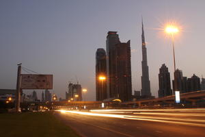 artificial lighting, cityscape, Dubai, Dubayy, dusk, eye level view, flyover, lamppost, outdoor lighting, road, sign, skyscraper, The United Arab Emirates