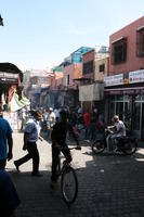 autumn, cycling, day, eye level view, group, man, market, Marrakech, Marrakesh, middleastern, Morocco, people, stall, sunny