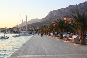 bench, boat, Croatia, dusk, evening, eye level view, Makarska, man, palm, people, promenade, sitting, Splitsko-Dalmatinska, tree, vegetation, walking, woman, yacht