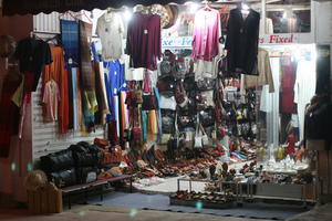 Agadir, artificial lighting, autumn, clothing, evening, eye level view, market, Morocco, object, souvenir, stall