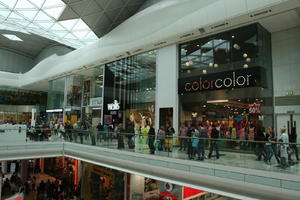 day, England, eye level view, group, indoor lighting, interior, London, mall, natural light, people, retail, shop, shopping, shopping centre, sign, The United Kingdom, walking