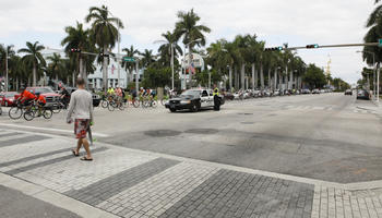 car, crossing, cycling, day, diffuse, diffused light, eye level view, Florida, group, Miami, pavement, people, police car, street, summer, The United States, walking