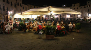 artificial lighting, cafe, chair, eating, eye level view, furniture, group, Italia , Lucca, night, outdoor lighting, outdoors, people, potted plant, sitting, square, summer, Toscana, umbrella