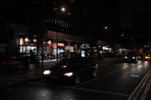 artificial lighting, car, city, city lights, England, eye level view, London, night, outdoor lighting, retail, shopfronts, street, The United Kingdom, urban