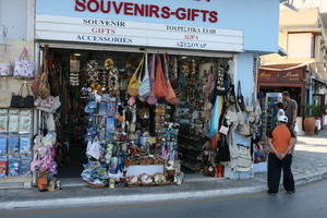 Agios Nikolaos, autumn, back, bag, clothing, day, eye level view, Greece, jewellery, Lasithi, man, object, people, retail, sign, souvenir, street