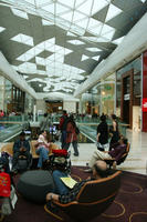 ceiling, day, England, eye level view, family, group, indoor lighting, interior, London, mall, mother and child, natural light, people, shopping centre, sitting, The United Kingdom