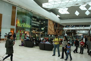 day, England, eye level view, group, indoor lighting, interior, London, mall, natural light, people, retail, shopping, shopping centre, sign, The United Kingdom, walking