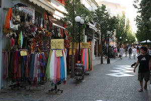 Agios Nikolaos, autumn, bag, clothing, day, eye level view, Greece, lamppost, Lasithi, object, people, retail, sign, souvenir, street, tourist, tree, vegetation