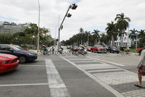 car, crossing, cycling, day, diffuse, diffused light, eye level view, Florida, group, Miami, pavement, people, street, summer, The United States